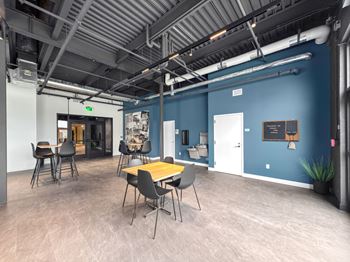 A room with a blue wall and a wooden table with chairs.at Plant 1 Lofts, N. Newton, IA 50208  